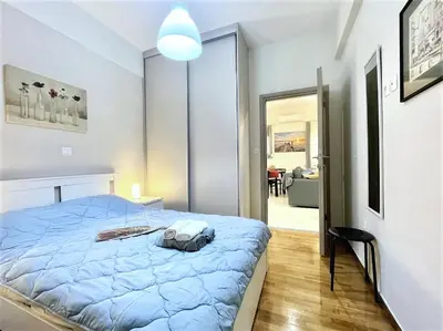 a bedroom with a blue bed in a room at Elegant & Modern Flat Near Panathenaic Stadium in Athens