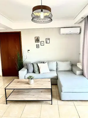 a living room with a couch and a coffee table at Kallikratis Apartment Near Athens Airport in Spáta