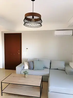 a living room with a couch and a coffee table at Kallikratis Apartment Near Athens Airport in Spáta