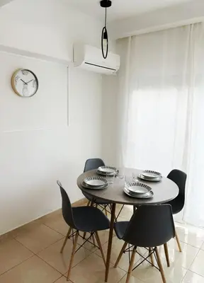 a dining room with a table and chairs at Kallikratis Apartment Near Athens Airport in Spáta