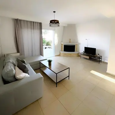 a living room with a couch and a coffee table at Kallikratis Apartment Near Athens Airport in Spáta