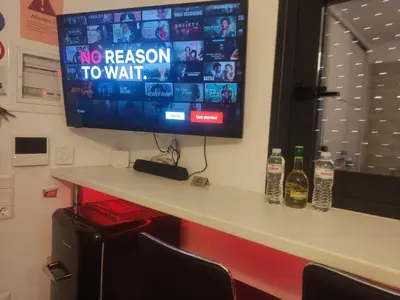 a tv sitting on top of a counter with bottles at Jacuzzi Suite and Family Apartment Near Acropolis in Athens