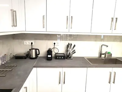 a kitchen counter with white cabinets and a sink at Jacuzzi Suite and Family Apartment Near Acropolis in Athens