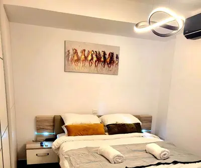 a bedroom with a bed and a painting on the wall at Jacuzzi Suite and Family Apartment Near Acropolis in Athens