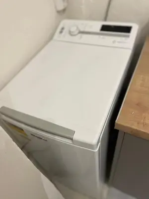 a white dishwasher in a kitchen next to a table at Vivian modern apartment in Athens