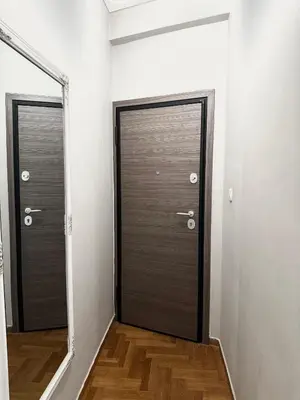 two doors in a room with wood floors and white walls at Vivian modern apartment in Athens