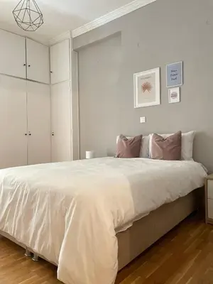 a bedroom with a large bed with white walls at Vivian modern apartment in Athens