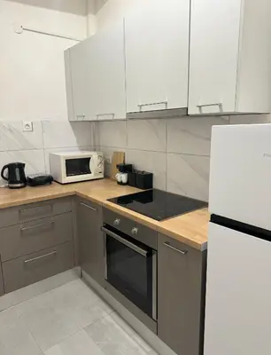 a kitchen with white cabinets and a white microwave at Vivian modern apartment in Athens