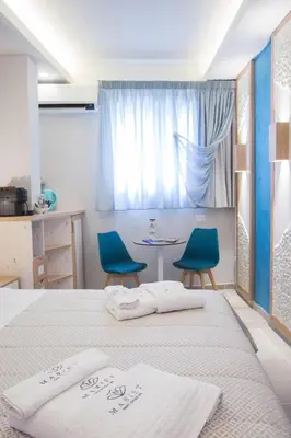 a bedroom with two beds and a table with blue chairs at Mariet Athens Boutique Spa in Athens