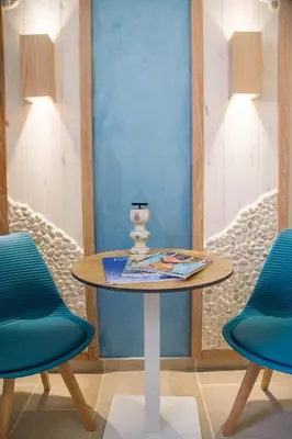 a table in a room with two blue chairs at Mariet Athens Boutique Spa in Athens