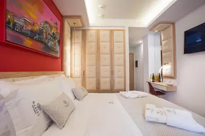 a bedroom with a white bed with a red wall at Mariet Athens Boutique Spa in Athens