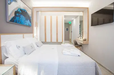a bedroom with a white bed and a mirror at Mariet Athens Boutique Spa in Athens