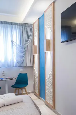 a bedroom with a blue chair and a table at Mariet Athens Boutique Spa in Athens