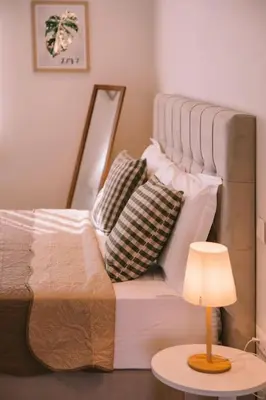 a white bed with pillows and a table with a lamp at Villa Diamond in Lagonissi with pool & garden in Kalívia Thorikoú