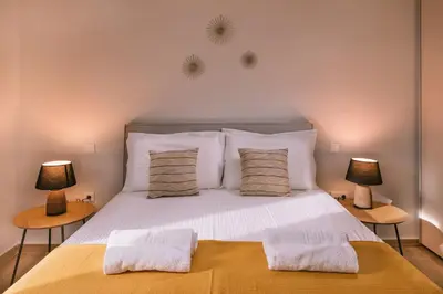 a bedroom with a large white bed with two lamps at Villa Diamond in Lagonissi with pool & garden in Kalívia Thorikoú