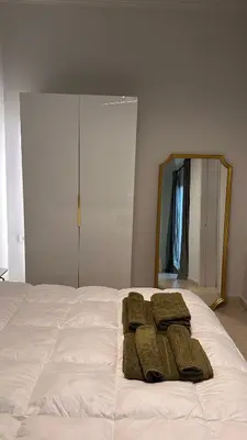 a bed with three towels on it with a mirror at The NOTARY in Athens
