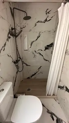 a bathroom with a white toilet and a shower at The NOTARY in Athens