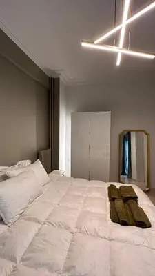 a large white bed with two brown towels on it at The NOTARY in Athens