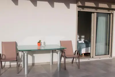 a dining room table with two chairs and a glass door at Elizabeth Studio in Athens