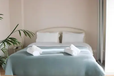 a white bed with two white towels on it at Elizabeth Studio in Athens
