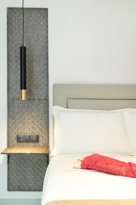 a bedroom with a white bed and a black lamp at Electra Urban Apartment Athens in Athens