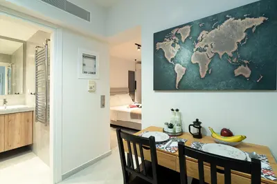 a dining room with a table and a map on the wall at Electra Urban Apartment Athens in Athens