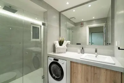 a bathroom with a washing machine and a sink at Electra Urban Apartment Athens in Athens