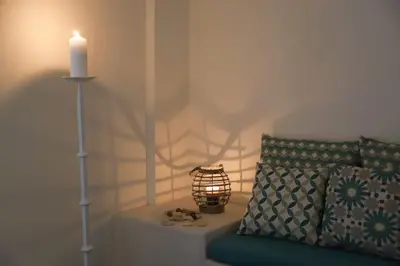 a candle sitting on a table next to a couch with a pillow at Mikaella Residence in Athens