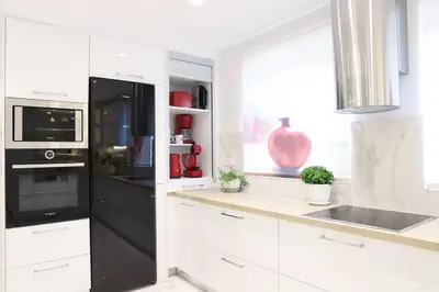 a kitchen with white cabinets and a black refrigerator at Mikaella Residence in Athens