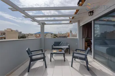 a patio with two chairs and a table on a balcony at Akali Apartment airport by Airstay in Spáta
