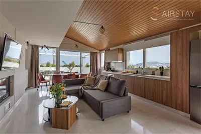 a living room with a couch and a kitchen at Akali Apartment airport by Airstay in Spáta