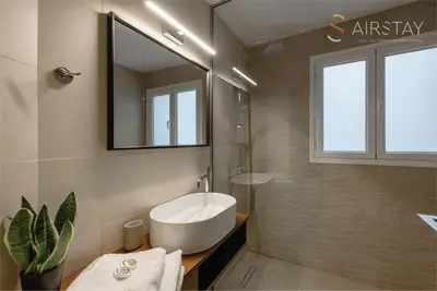 a bathroom with a tub and a sink and a mirror at Akali Apartment airport by Airstay in Spáta