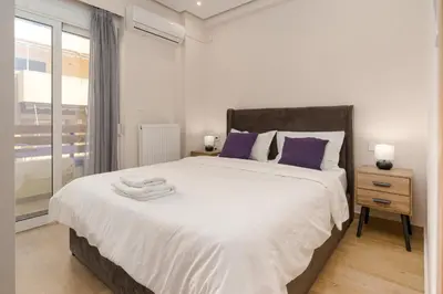 a bedroom with a large white bed with purple pillows at Chic Apartment near Acropolis in Athens
