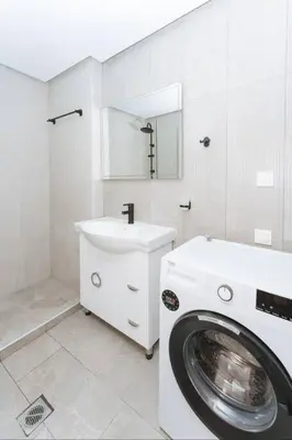 a white bathroom with a washing machine and a sink at Chic Apartment near Acropolis in Athens