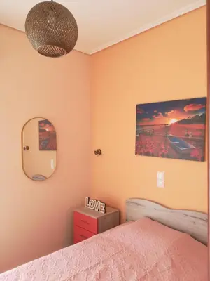 a bedroom with a bed and a mirror at GLYFADA APARTMENT 