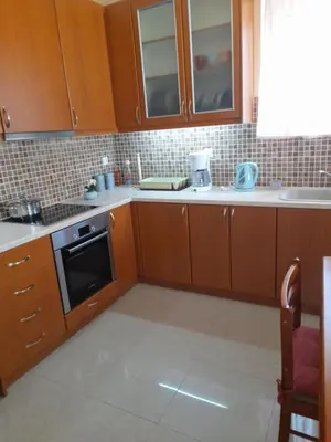 a kitchen with wooden cabinets and a stove top oven at GLYFADA APARTMENT 