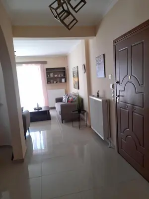 a living room with a door and a couch at GLYFADA APARTMENT 