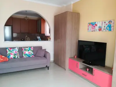 a living room with a couch and a flat screen tv at GLYFADA APARTMENT 