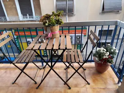 a table and chairs on a balcony with plants at Eleni’s House near to Thisio in Athens