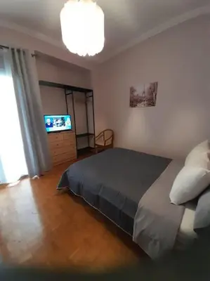 a bedroom with a bed and a flat screen tv at Eleni’s House near to Thisio in Athens