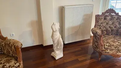 a statue of a woman in a living room with two chairs at Athens center vintage maisonete in Athens