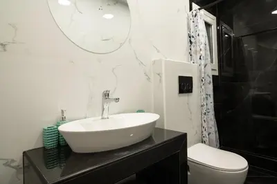 a bathroom with a sink and a toilet and a mirror at Lenorman Apartments in Athens