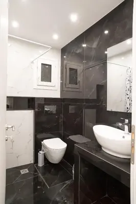 a black and white bathroom with a sink and a toilet at Lenorman Apartments in Athens