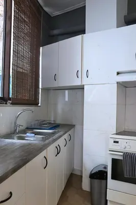 a kitchen with white cabinets and a sink at Athens Marialena Apartment in Athens