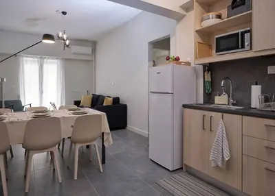 a kitchen and dining room with a table and a white refrigerator at Chic Apt with All Comforts in the Heart of Athens! in Athens