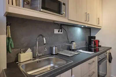 a kitchen with a sink and a microwave at Chic Apt with All Comforts in the Heart of Athens! in Athens