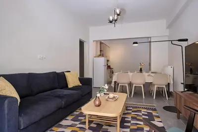 a living room with a blue couch and a table at Chic Apt with All Comforts in the Heart of Athens! in Athens