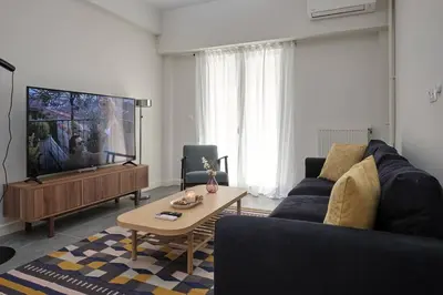 a living room with a couch and a tv at Chic Apt with All Comforts in the Heart of Athens! in Athens