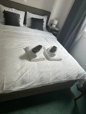 a white bed with two towels on top of it at Pnoé d Athéna in Athens