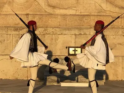 two men in traditional dances in front of a wall at Pnoé d Athéna in Athens